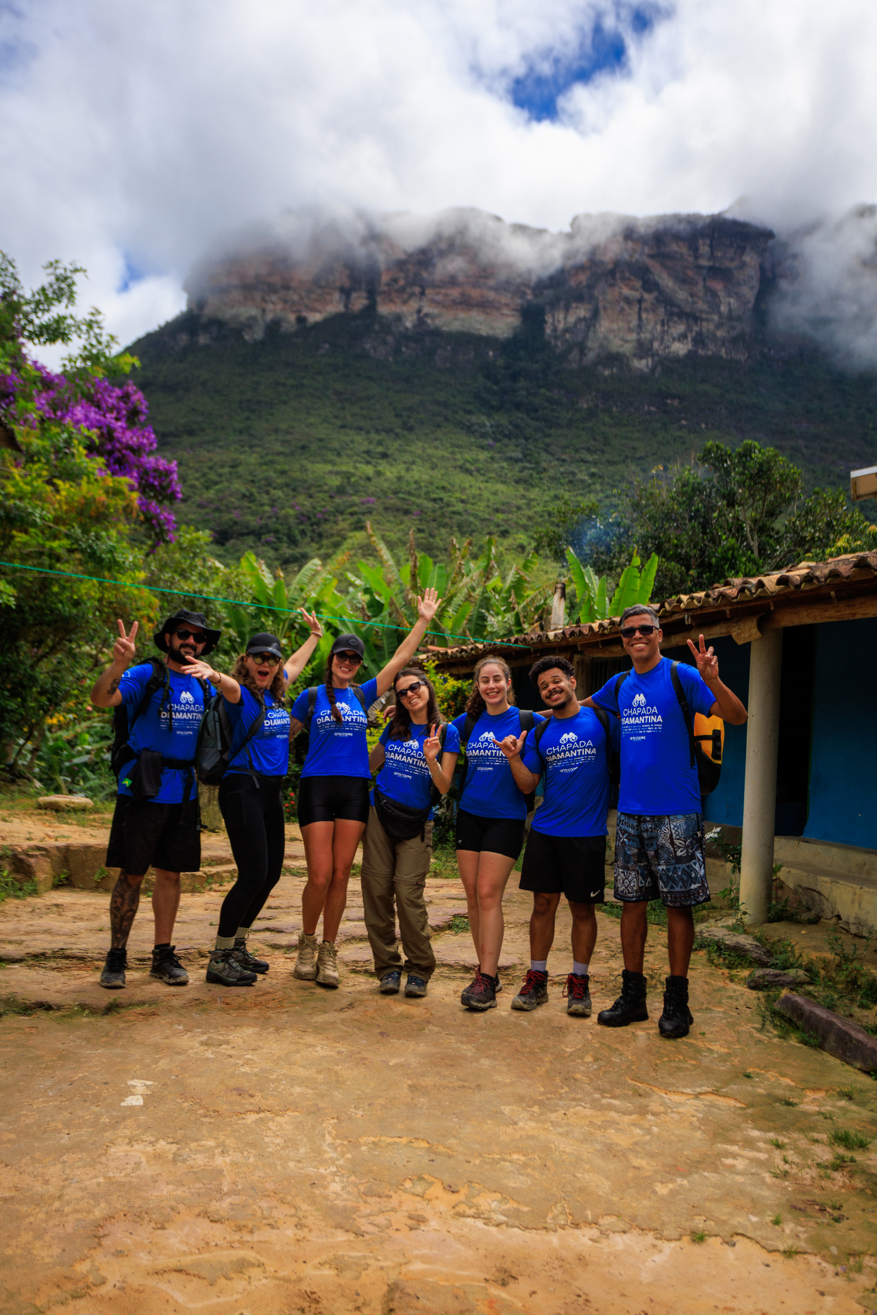 Grupo da expedição Chapada Diamantina posando feliz com camisetas azuis, montanha ao fundo